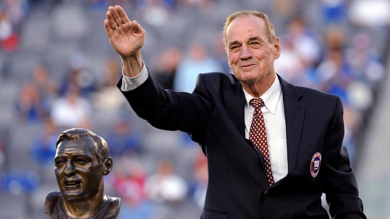 FILE - Former New York Giants linebacker Sam Huff waves to the fans as he stands behind his...