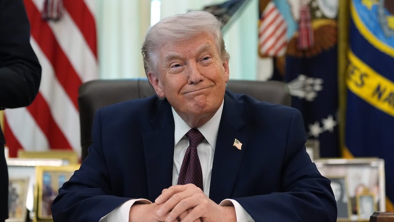 President Donald Trump listens in the Oval Office of the White House before signing an...
