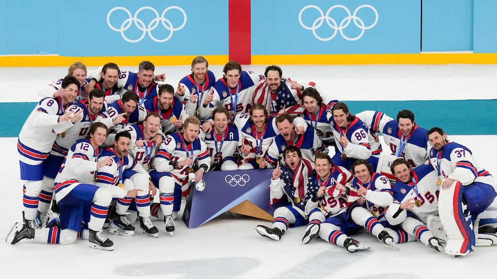 Team USA poses for a group photo after defeating Canada in the men's ice hockey gold medal...